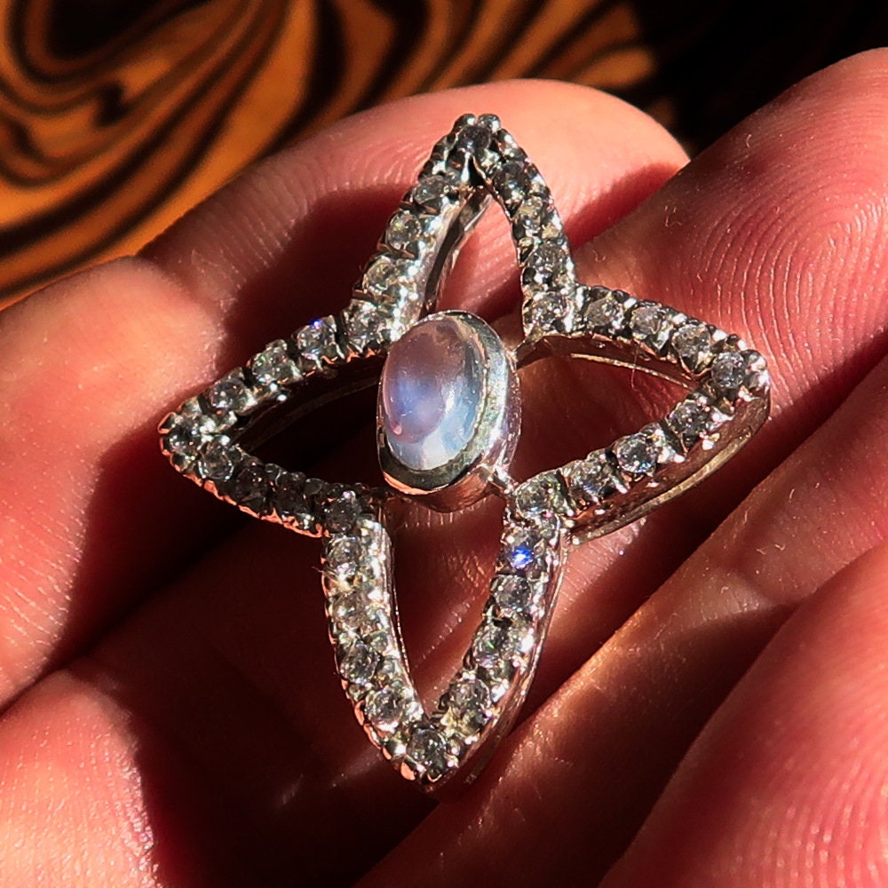 A beautiful sterling silver pendant necklace featuring a moonstone and cubic zirconias, showcasing its elegant design and craftsmanship.